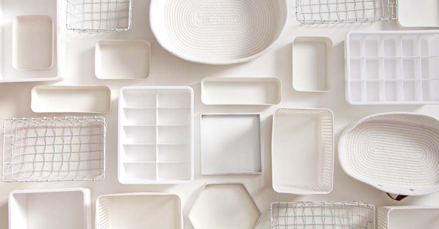 white plates, bowls and storage container on white table, top view
