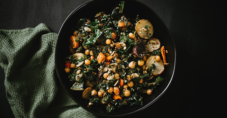 Black bowl filled with a chickpea and vegetable stir-fry