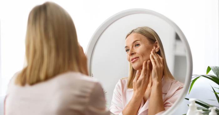 middle aged woman looking in mirror