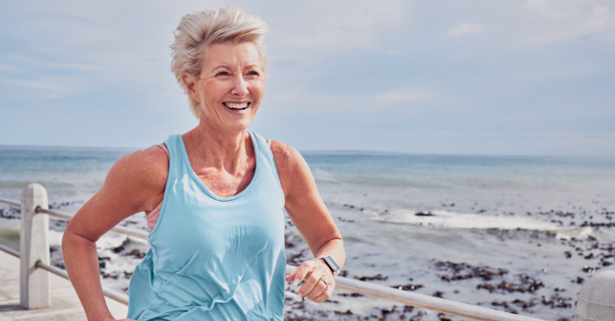 woman in her 40s running on beach