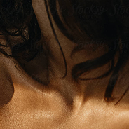 Close-up of a person's neck and shoulder with dark hair.