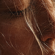 Close-up of a person's face with hair covering part of their face